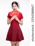 Portrait of joyful beauty Asian woman in red Cheongsam Chinese traditional dress celebrating with lucky red envelopes on Chinese New Year festival isolated on white background.