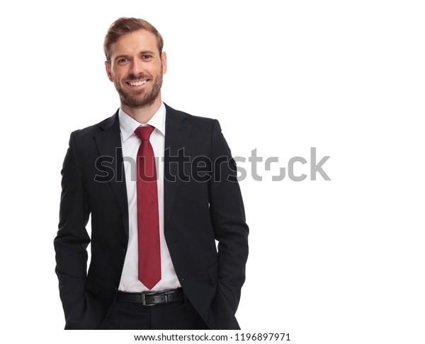 白い背景に手をポケットに入れた状態でスーツを着た喜びのビジネスマンと赤いネクタイのポートレート の写真素材 今すぐ編集