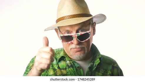 Portrait of a joyful elderly man in a straw hat and hawaiian shirt on a white background isolated. Crazy funny funky old man looking at camera and smiling.
 - Shutterstock ID 1748245289