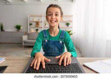 Portrait Of Joyful Excited Girl Studying Online, Using Laptop At Home, Webcam Point Of View Pov. Cute Teen Kid Having Online Lesson, Typing On Notebook Keyboard, Playing Game, Browsing Internet