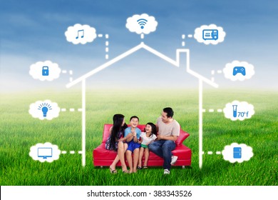 Portrait Of Joyful Family Having Fun Together On The Sofa Under A Design Of Smart Home Technology System 