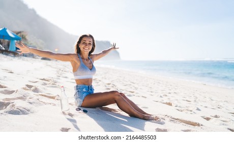 Portrait of joyful female tourist with bottle of water resting at Bahamas seashore rejoicing during summer recreation vacations on tropical island,happy Caucasian woman feeling good at coastline beach - Shutterstock ID 2164485503