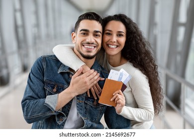 Portrait Of Joyful Millennial Arab Spouses With Passports And Tickets In Hands Posing At Airport Before Flight, Happy Young Middle Eastern Couple Ready For Honeymoon Trip, Enjoying Air Travels - Shutterstock ID 2145692677