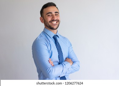 Portrait of joyful professional. Young business man blue shirt and tie crossing arms and smiling at camera. Successful businessman concept