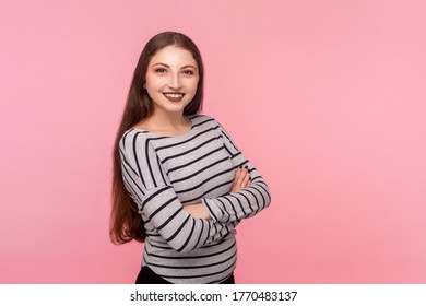 Portrait of joyful self-assured woman in striped sweatshirt looking at camera with toothy smile, crossing hands and feeling confident, satisfied with life. studio shot isolated on pink background - Shutterstock ID 1770483137