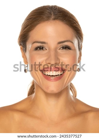 A portrait of a joyful woman with a beautiful smile and tasteful makeup,posing on white studio background, expressing happiness and confidence