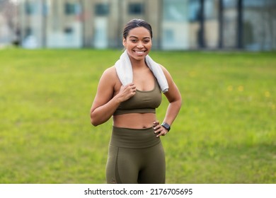 Portrait Of Joyful Young Black Woman In Sportswear With Towel Posing At Park, Copy Space. Athletic Millennial African American Female Leading Healthy Lifestyle, Smiling At Camera After Outdoor Workout