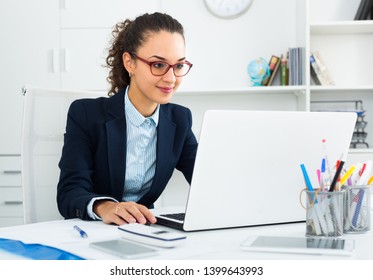 Portrait of joyful young businesswoman working in modern office