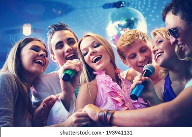 Portrait of joyous guys and girls singing at party together - Powered by Shutterstock