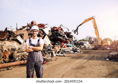 Portrait of junkyard worker standing in scrap metal recycling center.