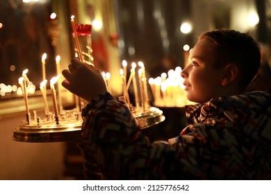 Portrait of kid with candle in russian orthodox church