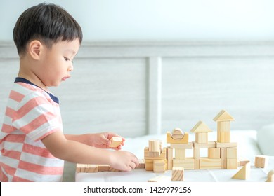 Portrait Of Kid Cute Asian Boy Playing A Blocks Wood Game. Selective Focus. Copy Space. Executive Functions Concept.