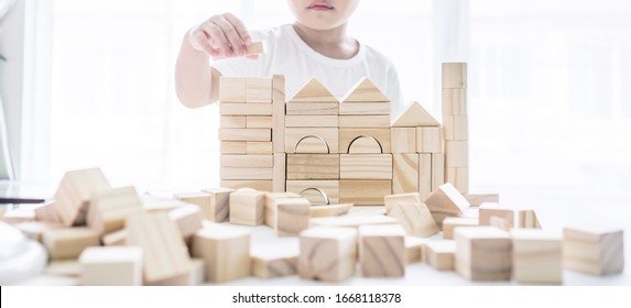 Portrait Of Kid Cute Asian Boy Playing A Blocks Wood Game. Selective Focus. Copy Space. Executive Functions Concept.