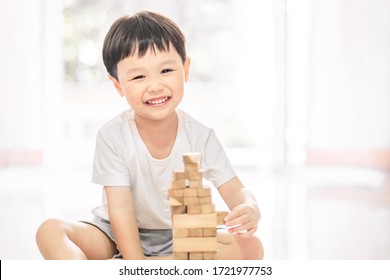 Portrait Of Kid Cute Asian Boy Playing A Blocks Wood Game. Selective Focus. Copy Space. Executive Functions Concept.