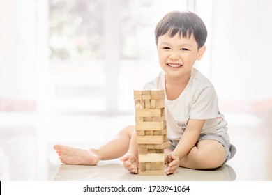 Portrait Of Kid Cute Asian Boy Playing A Blocks Wood Game. Selective Focus. Copy Space. Executive Functions Concept.