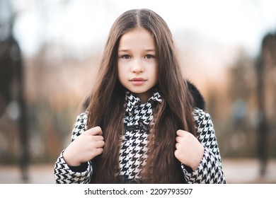 Portrait Of Kid Girl 10-12 Year Old With Long Blonde Hair Wear Casual Jacket In Park Outdoor. Look At Camera. Fall Season. 