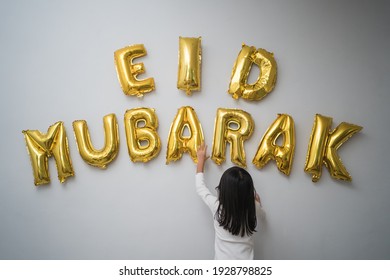 Portrait Kid Muslim Decorating Eid Mubarak Letter Made Of Baloon Decoration Against The Wall At Home