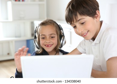 Portrait Of Kids Waving At Webcamera With Laptop