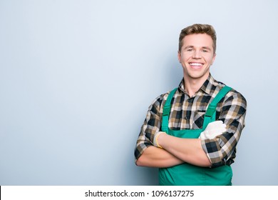 Portrait of kind cheerful excited smart professional friendly expert handsome with beaming shiny smile handyman wearing green overalls standing with folded hands isolated on gray background copyspace - Powered by Shutterstock