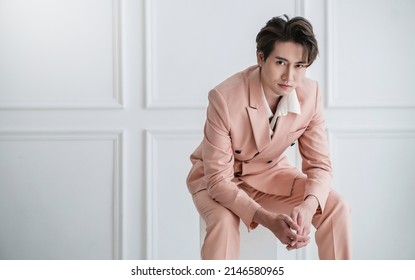 Portrait of Korean asian gut aussehenden Geschäftsmodell Mann in rosafarbenem Anzug Sitzen , Geschäftsmann clever mit Erfolg, Manager oder Geschäftsführer mit Leadership Office Mode-Arbeitsplatz.