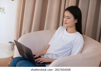 Portrait Of Korean Asian Woman Enjoying Using Laptop At Apartment Interior Indoor Living Room. Video Call Vlogger Webinar Stream Concept