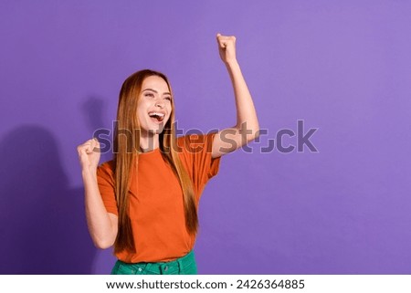 Portrait of lady in t shirt from popular clothing brand she raised fists up to celebrate discounts isolated on purple color background