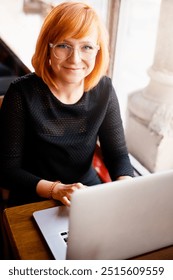 Portrait, laptop and happy woman in cafe for freelance design, online research or digital networking. Smile, computer and creative girl in coffee shop for remote work, planning and typing web article