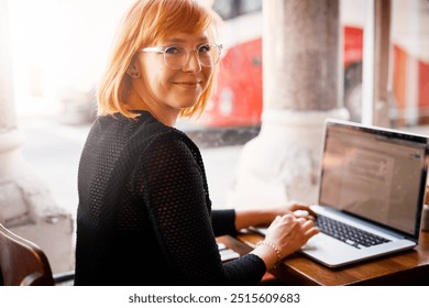 Portrait, laptop screen and woman in cafe for freelance design, online research or digital networking. Smile, computer and creative girl in coffee shop for remote work, planning or typing web article