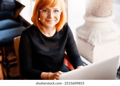 Portrait, laptop and woman in coffee shop for freelance design job, online research and digital networking. Smile, computer and creative girl in cafe for remote work, planning and typing web article