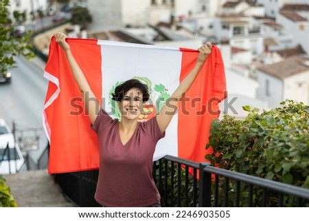 Portrait of a latin adult woman holding a Peruvian flag