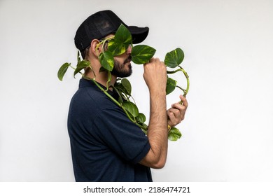 Portrait Of A Latin American Male Gardener Holding A Plant