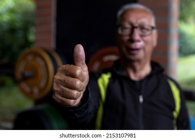 Portrait Of Latin American Senior Male At The Gym Raising His Right Thumb In Positive Attitude Of Approval. Healthy Lifestyle Concept.