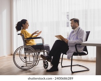 Portrait latin american woman sick sit wheelchair with man doctor caucasian sitting two people check and treat patients talk helping support explain medicine sick person inside hospital room service - Powered by Shutterstock