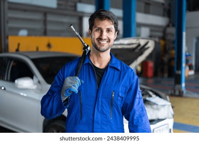 Portrait of latin auto mechanic man holding wrench standing in garage cars service . hispanic technician repairing vehicle at garage . maintenance car repair service - Powered by Shutterstock