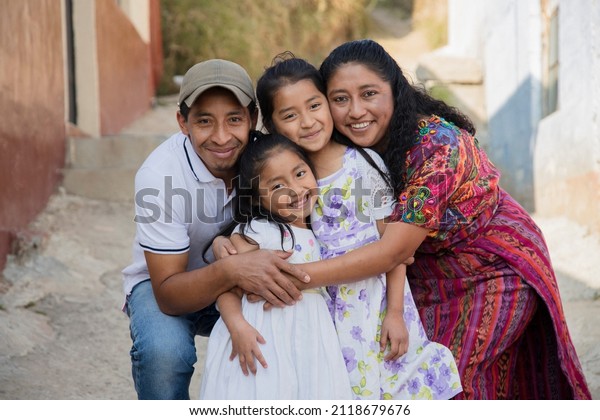 Portrait of a Latin family hugging in rural\
area - Happy Hispanic family in the\
village