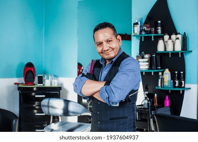 Portrait Of Latin Man Barber Holding Equipments In Hand, Looking At Camera In A Barber Shop Small Business In Mexico City