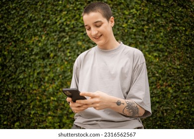 Portrait of Latin transgender generation z person using mobile phone  - Powered by Shutterstock
