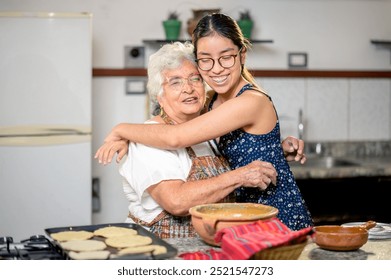 Portrait of a Latina grandmother and granddaughter hugging each other. - Powered by Shutterstock