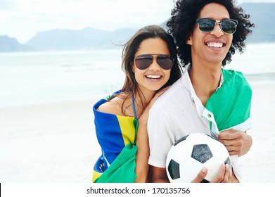 Portrait of latino couple with Brasil flag and soccer ball for world cup
