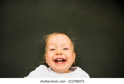 Portrait Of Laughing Baby With Standing Hair From Static Electricity