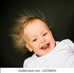 Portrait Of Laughing Baby With Standing Hair From Static Electricity