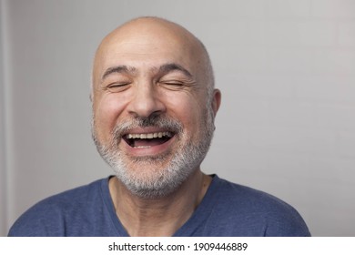 Portrait Of A Laughing Handsome Man 50 Years Old In Blue T-shirt Indoors. Positive Emotions. Lifestyle Concept.