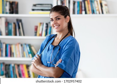 Portrait of laughing hispanic female nurse at work at hospital