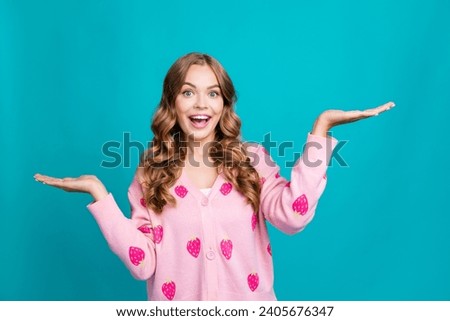 Portrait of laughing positive barbie girl in pink glamour jumper hold two arms compare commerce offers isolated on blue color background