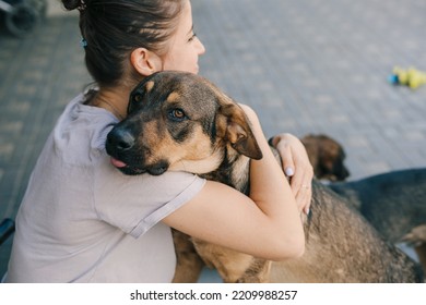 Portrait Of Laughing Woman Embracing Dog, Enjoying Good Day And Posing With Pet On Backyard. Embracing Purebred Pet. Female Owner And Pet. Authentic Lifestyle