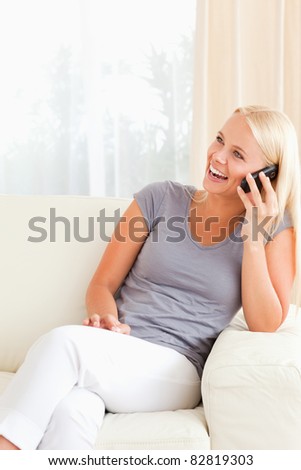 Portrait of a laughing woman on the phone in her living room