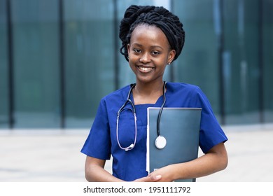 Portrait Of Laughing Young Black Lady Doctor With Stethoscope, Trendy African American Woman With Dreadlocks In Uniform, Smiling Afro Girl Medical Student  At College, University, Hospital, Clinic