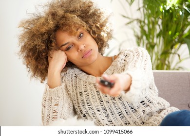 Portrait Of Lazy African American Girl Holding Tv Remote Control