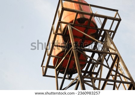 portrait of a leaking water tank tower taken from the bottom angle