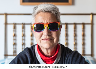 Portrait Of Lesbian Older Lady With Short Gray Hair Wearing Rainbow Gay Pride Flag Sunglasses.